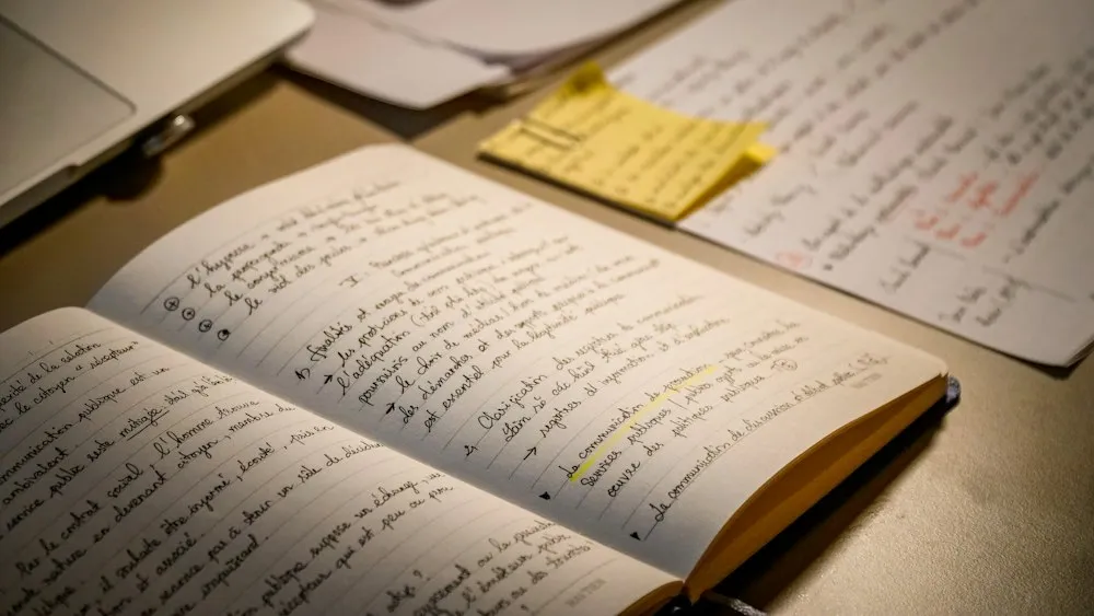 Open study notebook and notes on a wooden desk