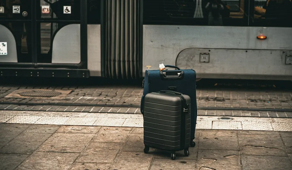 Travel suitcases waiting beside a bus