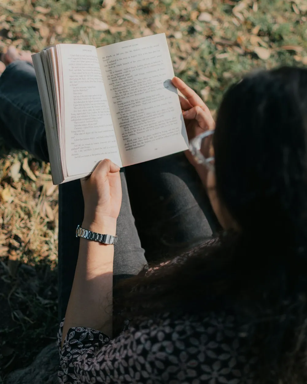 Woman enjoying reading a book in the grass